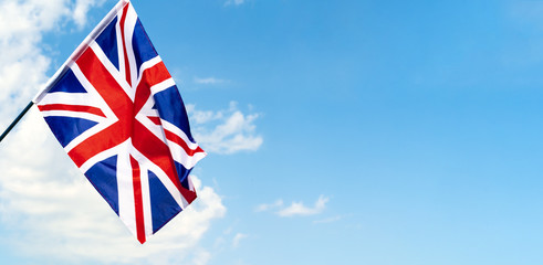 United Kingdom Flag waving on wind in blue sky