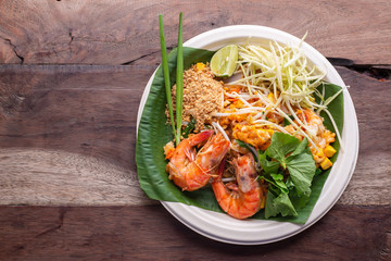 Pad Thai, Phad Thai, Asian Cuisine , Rice noodles with shrimps and vegetables close-up on the table, traditional Thai dish with stir fried rice noodles, shot from above on a rustic texture .