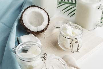 Organic healthy coconut butter and fresh coconut pieces on wooden board
