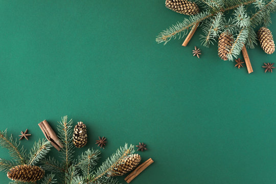 Christmas green background with fir tree and cones, cinnamon, anise. Flat lay, top view with copy space