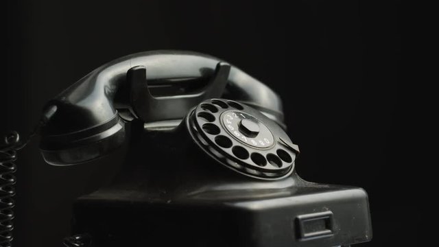 An old telephone on black background