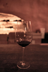 Wine glass with grape wine on bar