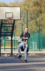 Hipster girl posing with a skateboard.