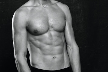 muscular man with naked torso on black background