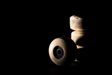 Isolated skateboard wheels on black background, low key, single light