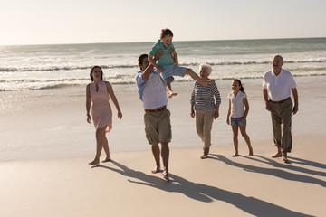 Happy multi-generation family walking and having fun on beach