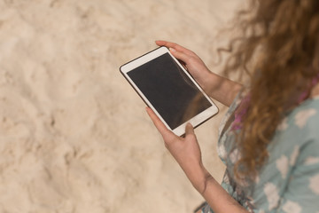 Young Caucasian woman using digital table on beach