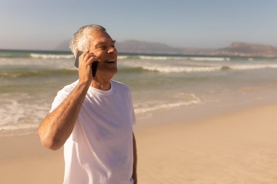 Senior man talking on mobile phone at beach