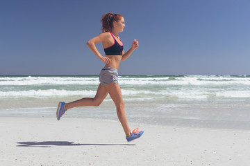 Young woman running at beach on a sunny day