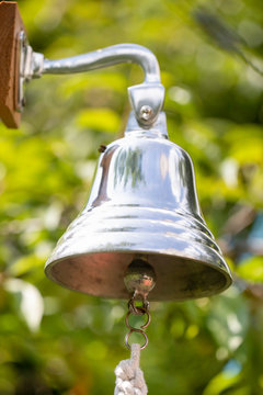 Ship's Bell In The Garden, Silver Object On Green Background.