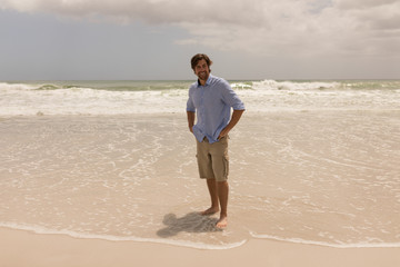Man standing with hands on hip on the beach