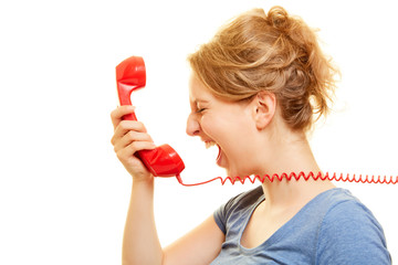 Young angry woman loudly roars in telephone receiver
