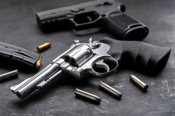 Gun with ammunition on dark background. 