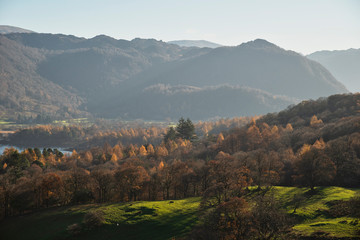 Fototapeta na wymiar Beautiful Autumn Fall landscape image of the view from Catbells in the Lake District with vibrant Fall colors being hit by the late afternoon sun