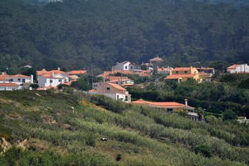 Fototapeta na wymiar Panoramic view of white-yellow-brown mediterranean town from the mountain. Cabo da Roca, Portugal