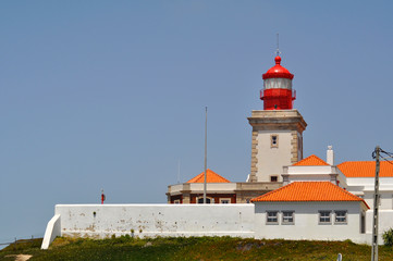 Beautiful old red-white mediterranean lighthouse on top of the hill. Cabo da Roca, Portugal