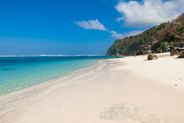 Tropical beach with white sand, blue ocean and waves