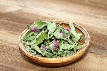 Bowl of dried  bergamot. Flowers of bergamot, Monarda didyma, on woodem board