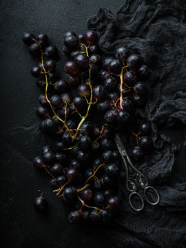 Dark grapes top view flatlay with dark fabric closeup
