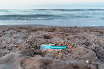 A blue kid shovel abandoned on the beach