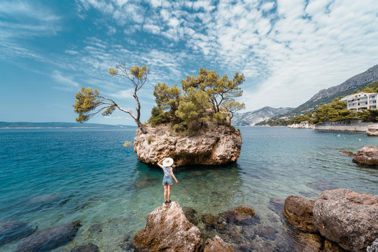 A young woman with a straw hat looking the Kamen Brela in Dalmatia, Croatia