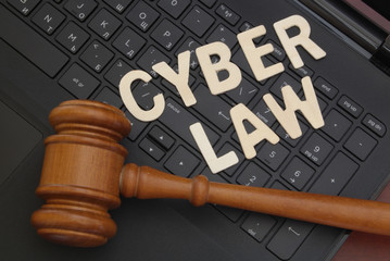 Cyber law concept, wooden judge gavel on computer keyboard