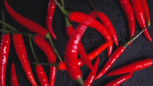 Red pepper. Red pepper rotates on a background of red pepper. Food video. Video for restaurants and cafes. Food performance. Macro shot of chili peppers. Many peppers lie on a black background.
