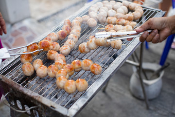 Grilled Isaan sausage on a charcoal stove