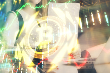 Cryptocurrency hologram over woman's hands writing background. Concept of blockchain. Double...