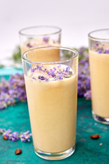 Summer drink iced coffee with lavender in glass and coffee beans on green background. Good Morning concept. Baeutiful ice coffee.