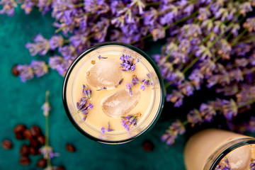 Summer drink iced coffee with lavender in glass and coffee beans on green background. Good Morning...