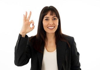 Portrait of a young beautiful smiling business woman doing O.K. sign. Isolated on white background