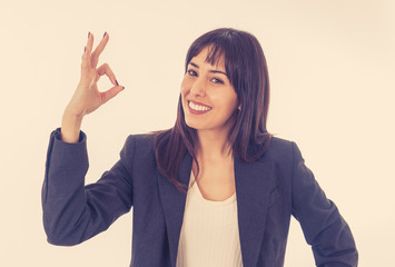 Portrait of a young beautiful smiling business woman doing O.K. sign. Isolated on white background