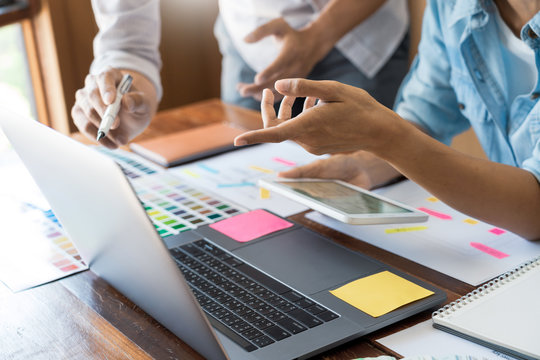 Creative UI designer teamwork meeting planning designing wireframe layout  application development mockup on smartphone screen for web mobile phone technology.