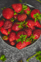 Ripe red strawberries on black table, Strawberries in white bowl. Fresh strawberries. grey strawberries. Diet food. Healthy, vegan. Top view. Flat lay. Copy space.