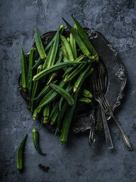 Okra Gumbo Ladyfinger fruit on vintage french platter with cutlery metal surface