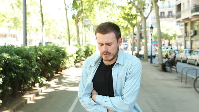 Man suffering stomach ache complaining in the street