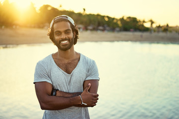 Handsome and confident. Outdoor portrait of smiling young african man on tha beach.