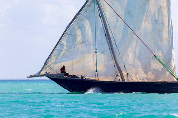 transport dhow showing detail of the hull and sails flapping in the wind
