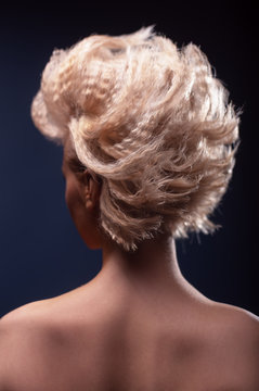 Beautiful closeup curly blonde hair on dark backdrop.