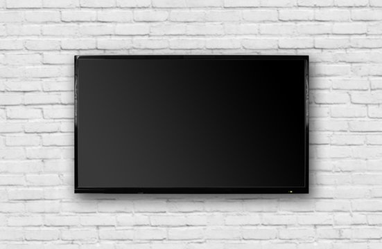 LCD TV with a thin black frame hanging on a white brick wall. Blank black screen. Isolated on white background