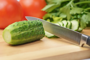 Chopping board with tomato, cucumber, parsley and knife