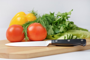 Chopping board with tomato, parsley and knife