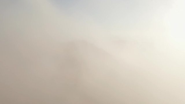 Dramatic 3-axis motion aerial footage of the cloudy summit of an old volcano in Bali, Mount Batur at high winds.