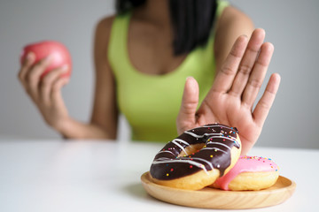 Women push the donut plate that is a mixture of trans fat. And choose to hold the apple. Don't eat...