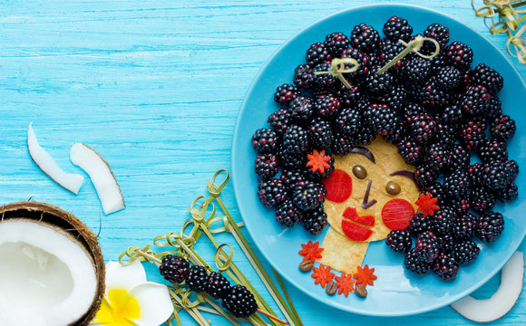 Fun food idea for kids - edible hawaiian girl face from pancake and blackberry, food art