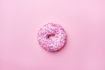 Fototapeta na wymiar Pink doughnut on a pink background. Top view Flat lay.