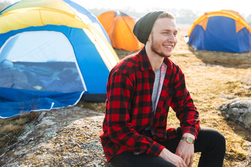 Man outside with tent in free alternative vacation camping over mountains.