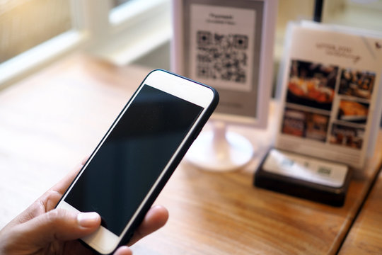 Hands Use The Phone To Scan QR Codes To Accumulate Points In Restaurants.