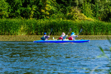 Fototapeta na wymiar Senior man and two women kayaking on Dnieper river